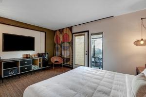 um quarto com uma cama e uma televisão de ecrã plano em Mahala em Palm Springs