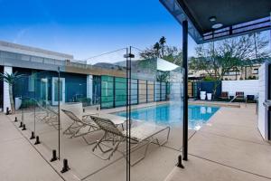 a patio with chairs and a swimming pool at Mahala - 21 and Over in Palm Springs