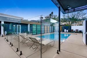 a patio with chairs and a swimming pool at Mahala in Palm Springs