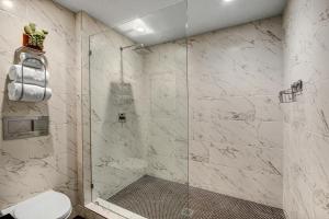 a bathroom with a shower with a toilet at Mahala - 21 and Over in Palm Springs +3 photos