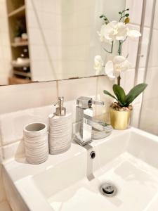 a bathroom sink with a faucet and white dishes at London Eye Centre Flat in London