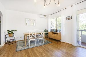 uma sala de jantar com paredes brancas e uma mesa e cadeiras em Zoo View Apartment - EXECUTIVE ESCAPES em Perth