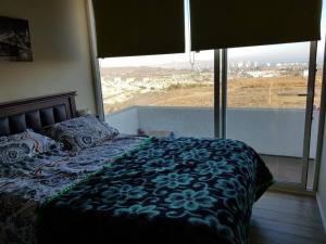 1 dormitorio con cama y ventana grande en Tranquilidad Veraniega Pet Friendly, en La Serena