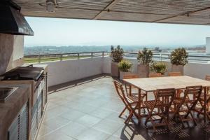 patio con mesa y sillas en el balcón en Tranquilidad Veraniega Pet Friendly, en La Serena