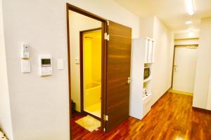 une porte ouverte dans une pièce avec une cuisine dans l'établissement Chura Gahna House Tsubogawa Naha, à Naha