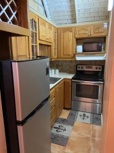 a kitchen with wooden cabinets and a stainless steel refrigerator at #73 Fisherman's Point in Ocho Rios