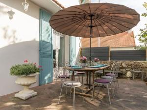 eine Terrasse mit einem Tisch, Stühlen und einem Sonnenschirm in der Unterkunft Gîte Bouvron, 6 pièces, 11 personnes - FR-1-306-838 in Bouvron