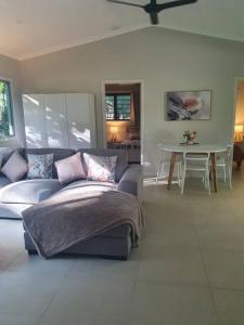 ein Wohnzimmer mit einem Sofa und einem Tisch in der Unterkunft Adorable 2 bedroom unit, set in lush gardens in McMinns Lagoon
