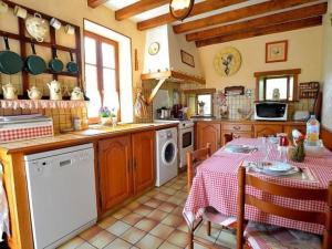 a kitchen with a table with a red and white table cloth at Longère XIXe rénovée avec spa, trampoline, vélos, jeux et grand jardin au calme - FR-1-410-135 in Saint-Calez-en-Saosnois