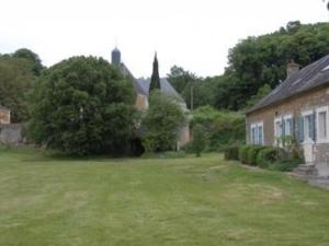 un cortile verde con una casa e una casa di Gîte spacieux rénové en 1850 avec grand jardin, terrasse, jeux pour enfants et équipements modernes ! - FR-1-410-172 a Pontvallain 1 altra foto