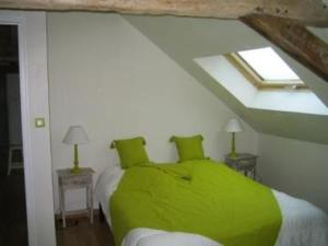 una camera da letto con letto verde in mansarda di Gîte spacieux rénové en 1850 avec grand jardin, terrasse, jeux pour enfants et équipements modernes ! - FR-1-410-172 a Pontvallain