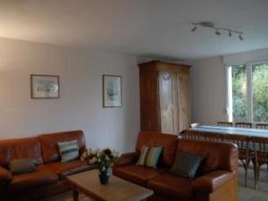 a living room with brown leather couches and a table at Gîte Montreuil-le-Henri, 5 pièces, 10 personnes - FR-1-410-184 in Montreuil-le-Henri