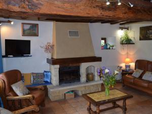 a living room with a fireplace and a tv at Charme et Authenticité en Forêt Maine Normandie : Demeure Rénovée avec Jardin, Idéale pour Séjour Détente - FR-1-410-186 in Crissé