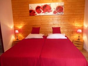 1 Schlafzimmer mit 2 Betten mit roter Bettwäsche und 2 Lampen in der Unterkunft Gîte Coulans-sur-Gée, 5 pièces, 8 personnes - FR-1-410-205 in Coulans-sur-Gée