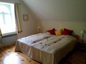 een slaapkamer met een groot wit bed met rode kussens bij Gîte Dureil, 6 pièces, 8 personnes - FR-1-410-208 in Dureil