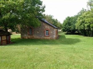 an old brick building in a field of grass at Gîte familial & authentique avec jardin arboré, entre Angers & Le Mans, idéal visites & détente - FR-1-410-208 in Dureil