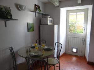 comedor con mesa con sillas y nevera en Gîte Asnières-sur-Vègre, 3 pièces, 5 personnes - FR-1-410-237, en Asnières-sur-Vègre