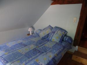 um quarto com uma cama com edredão e almofadas azuis em Gîte Asnières-sur-Vègre, 3 pièces, 5 personnes - FR-1-410-237 em Asnières-sur-Vègre