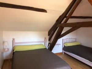 two beds in a room with wooden beams at Longère rénovée proche du Mans avec jardin et salle de jeux - FR-1-410-248 in Moncé-en-Belin