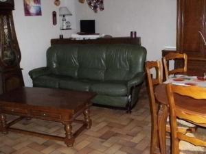 sala de estar con sofá verde y mesa en Gîte Saint-Vincent-du-Lorouër, 4 pièces, 6 personnes - FR-1-410-200, en Saint-Vincent-du-Lorouër