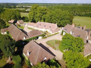 una vista aerea di un gruppo di case con tetti di Gîte charmant avec piscine chauffée, tennis et jardin près de Beaumont-sur-Sarthe - FR-1-410-214 a Maresché