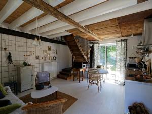 LouplandeにあるGîte cosy à la ferme près du Mans - Jardin, Terrasse, Poêle à bois, et Sérénité Rurale - FR-1-410-269のテーブルと椅子のあるキッチンとリビングルーム