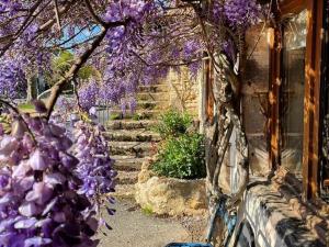 a bunch of purple flowers on a building at À louer : Ancienne forge avec sauna, piscine, proche plage et sites historiques - FR-1-591-193 in Le Menoux