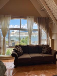 un sofá en una sala de estar con una gran ventana en #73 Fisherman's Point en Ocho Rios
