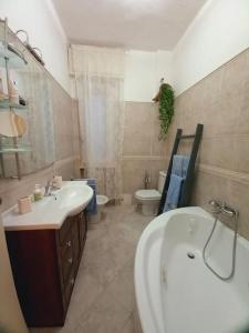 bagno con lavandino, vasca e servizi igienici di casa di Angela ad Acqui Terme