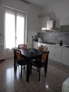 a kitchen with a table and chairs in a kitchen at casa di Angela in Acqui Terme