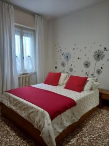 a bedroom with a large bed with red pillows at casa di Angela in Acqui Terme