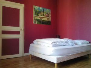 ein Schlafzimmer mit einem weißen Bett in einer roten Wand in der Unterkunft Gîte Futeau, 4 pièces, 6 personnes - FR-1-585-13 in Futeau
