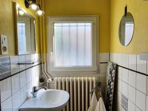 łazienka z umywalką, oknem i grzejnikiem w obiekcie Charmante maison rénovée avec jardin, proche de Verdun, idéale pour familles, draps et chauffage inclus - FR-1-585-50 w mieście Sivry-sur-Meuse