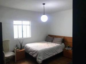 1 dormitorio con cama y ventana en Departamento en Colonia Roma con 2 habitaciones, en Ciudad de México