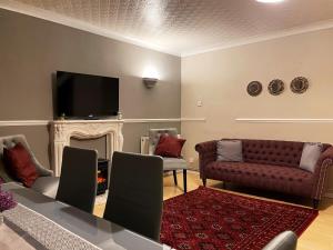 a living room with a couch and a fireplace at Vintage 3 Bedroom House near Catford in London