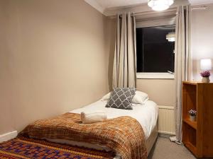 niewielka sypialnia z łóżkiem i oknem w obiekcie Vintage 3 Bedroom House near Catford w Londynie