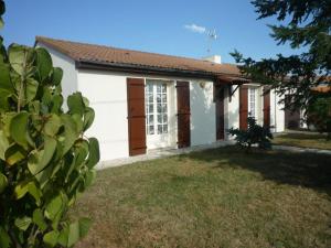 une petite maison blanche avec une cour d'herbe dans l'établissement Gîte Saint-Denis-du-Payré, 3 pièces, 4 personnes - FR-1-426-403, à Saint-Denis-du-Payré