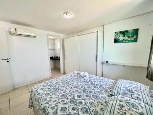 1 dormitorio con 1 cama con edredón azul y blanco en Duna Barcane Vista Mar Pontanegra Natal RN, en Natal