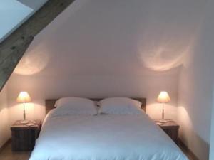 1 dormitorio con 1 cama blanca y 2 lámparas en Gîte Saint-Calais-du-Désert, 4 pièces, 6 personnes - FR-1-600-161, en Saint-Calais-du-Désert