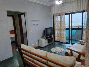 - un salon avec un canapé et une télévision dans l'établissement Apto no melhor ponto da Enseada, à Guarujá