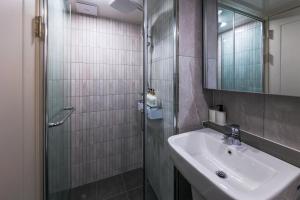 ein Bad mit einem Waschbecken und einem Spiegel in der Unterkunft Well stay in Incheon