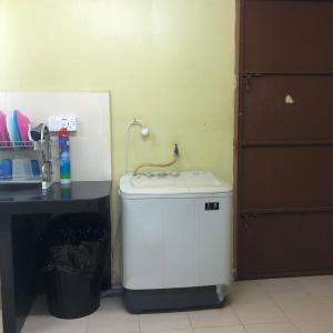 eine kleine Waschmaschine in einer Küche mit einer Theke in der Unterkunft ANGAH HOMESTAY LANGKAWI in Kuah