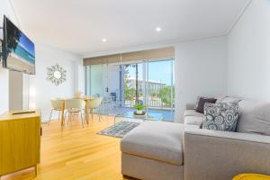 a living room with a couch and a table at Resort Rooms at Bells Boulevard in Kingscliff