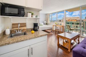 een keuken met een wastafel en een woonkamer bij @ Marbella Lane - Marina Studio near the beach in Honolulu