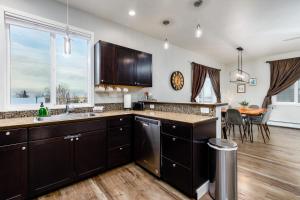 a kitchen with black cabinets and a dining room at Dawn A New Day, #2 in Eagle River