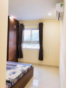 a bedroom with a bed and a window at Căn hộ hướng núi mới ở thành phố Quy Nhơn in Quy Nhon