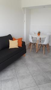 a living room with a black couch and a table at SANFER in San Fernando