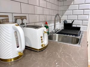 a kitchen counter with a toaster and a sink at Elegant & Cozy, Gold Decor Apartment, B1 in Birmingham