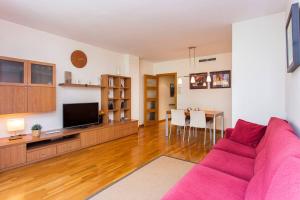 ein Wohnzimmer mit einem rosa Sofa und einem TV in der Unterkunft Fabulous Flat By Paseo De Gracia in Barcelona