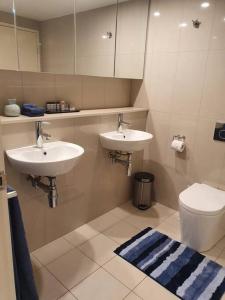 a bathroom with two sinks and a toilet at Rosie's at Darwin in Darwin